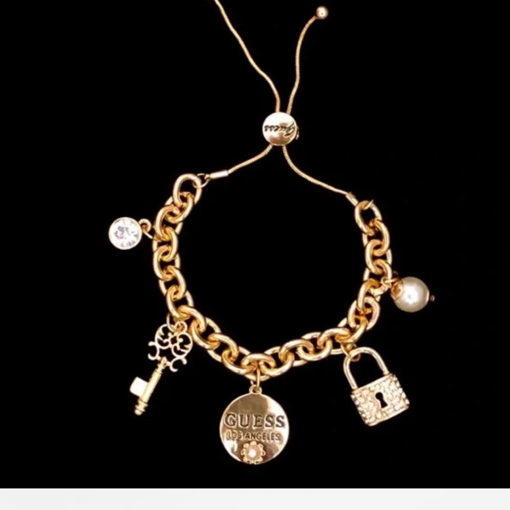Gold Guess bracelet with pearl and lock charms